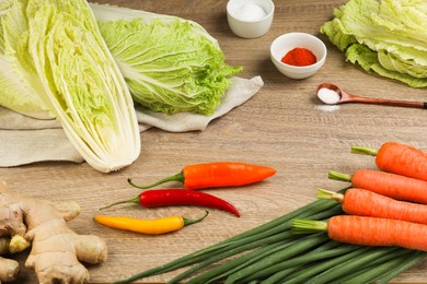 Photo of Fresh Chinese cabbages and ingredients on wooden table