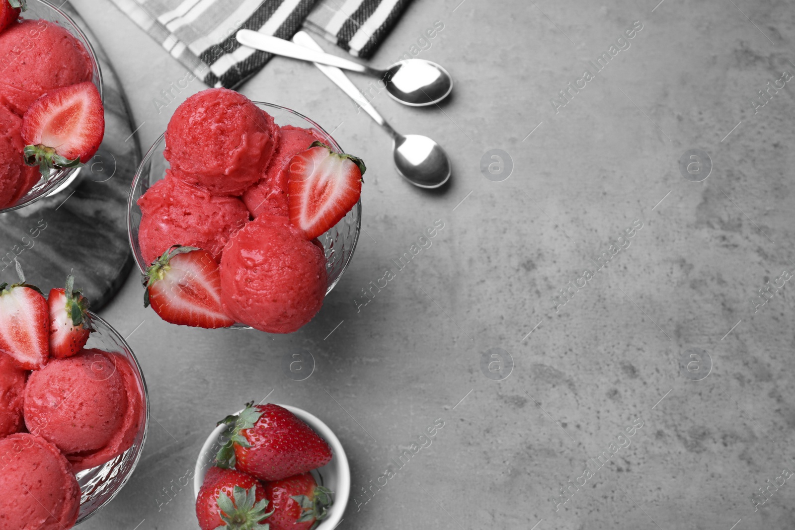 Photo of Delicious strawberry ice cream served on grey table, flat lay. Space for text