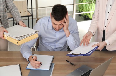 Photo of Businessman stressing out at workplace in office