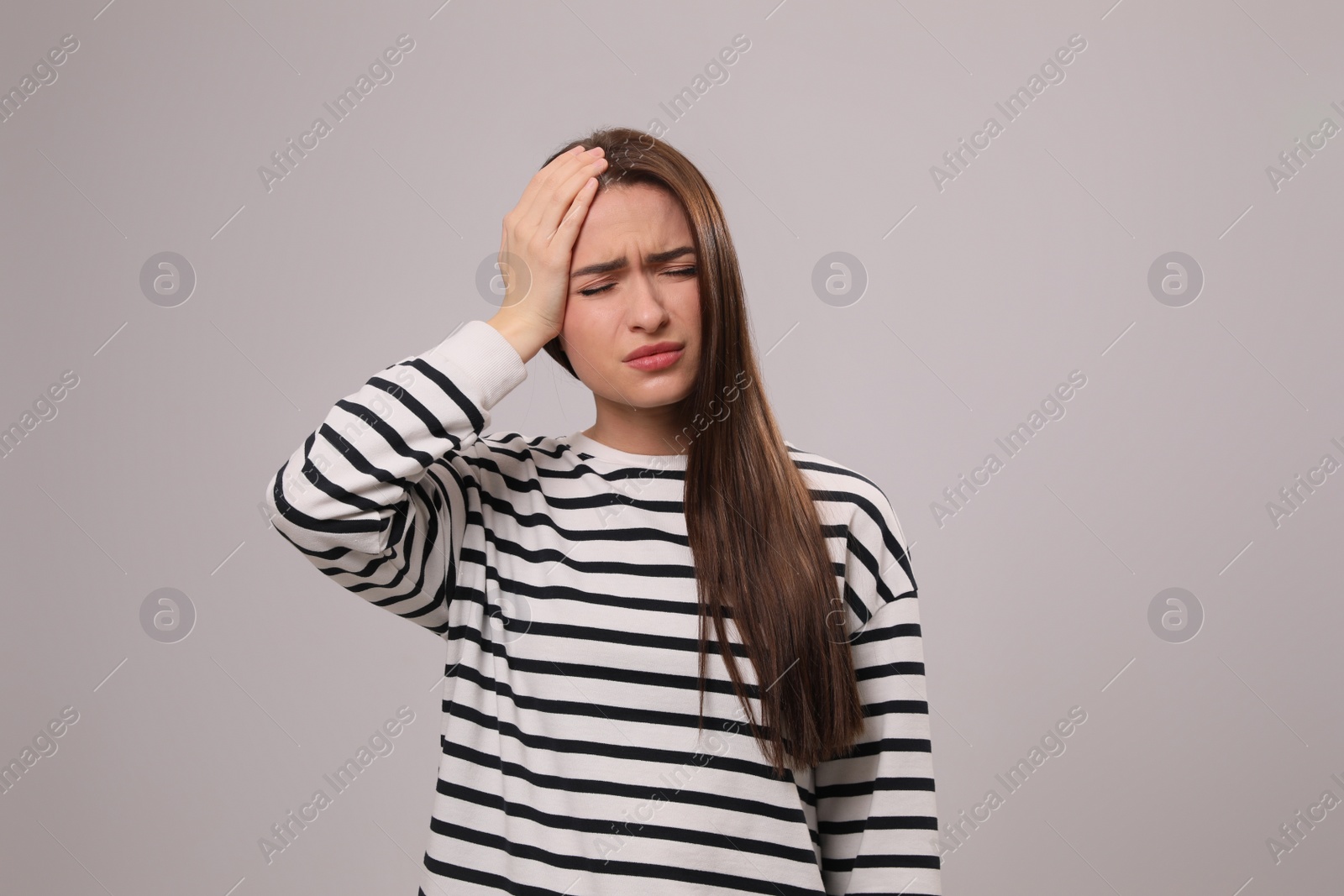 Photo of Woman suffering from headache on light grey background. Cold symptoms