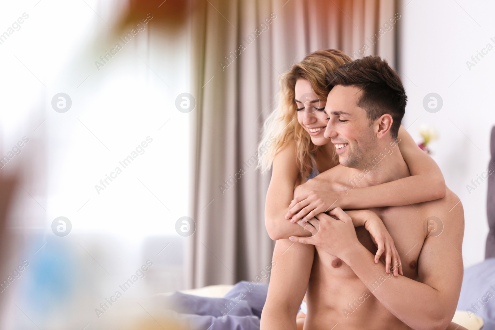 Photo of Sexy young couple being intimate on bed at home