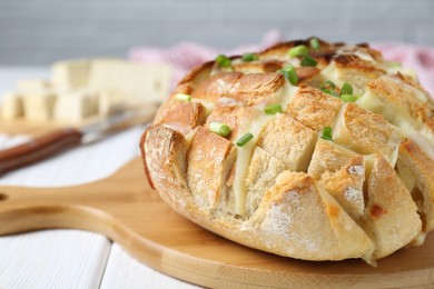 Freshly baked bread with tofu cheese and green onions on white wooden table, closeup