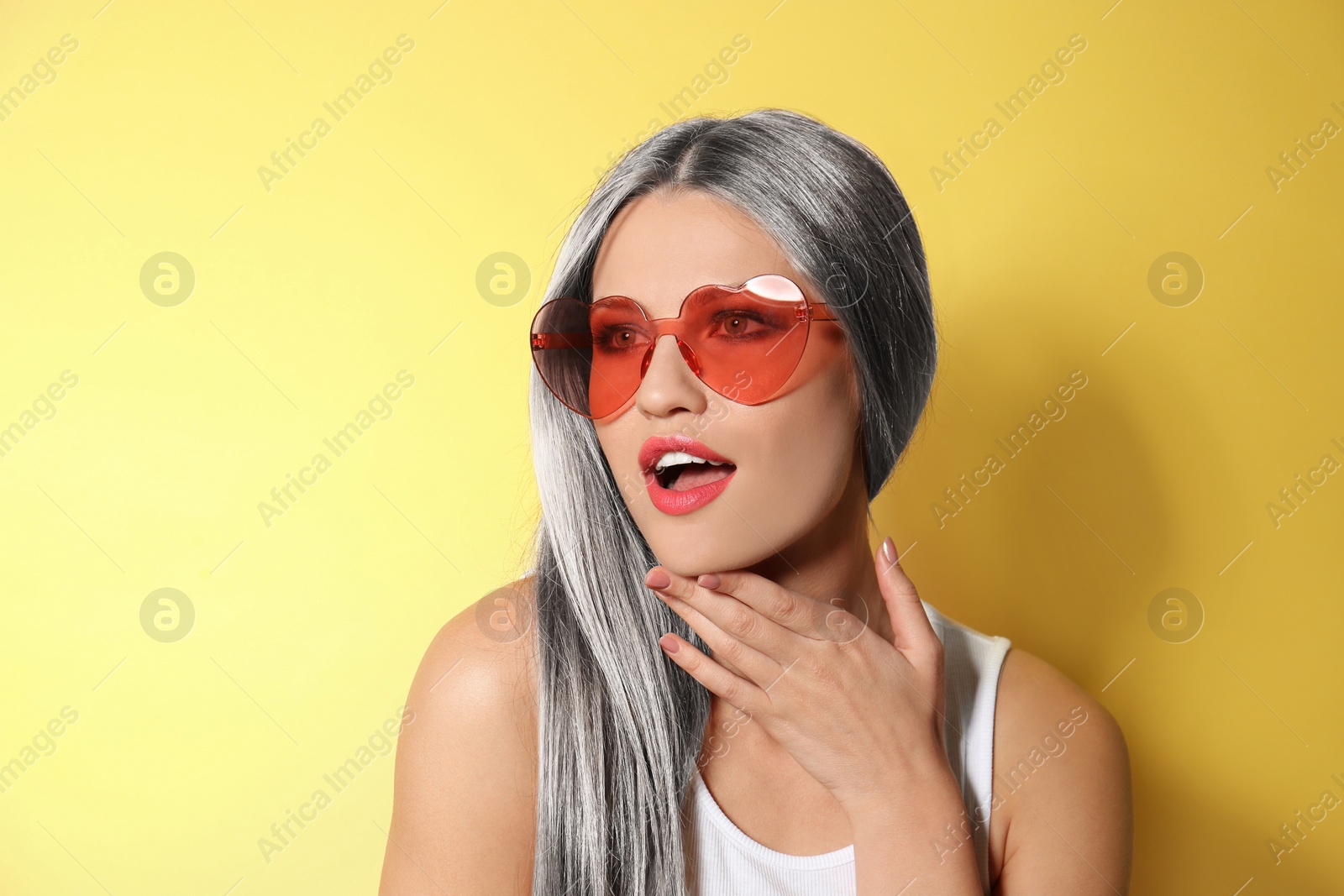 Image of Portrait of young woman with beautiful grey colored hair on yellow background