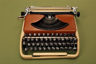 Old vintage typewriter machine on dark green background