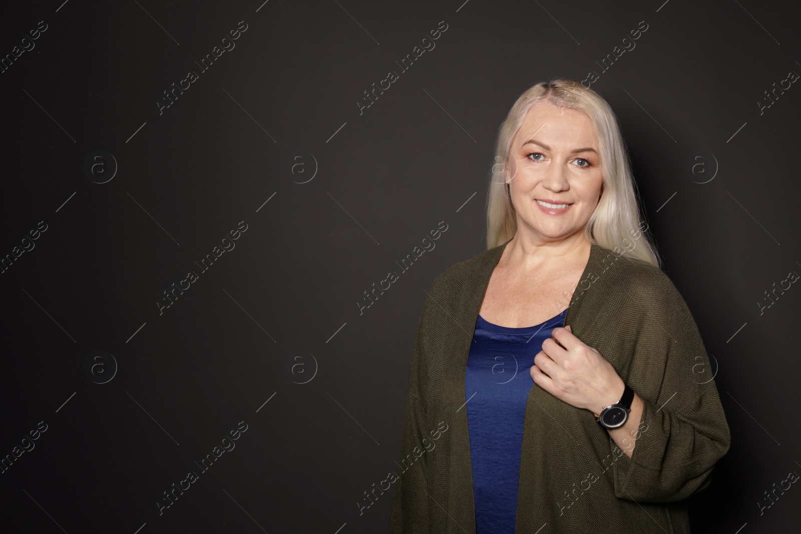 Photo of Portrait of mature woman on black background. Space for text