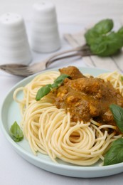 Photo of Delicious pasta and chicken with curry sauce served on white table, closeup