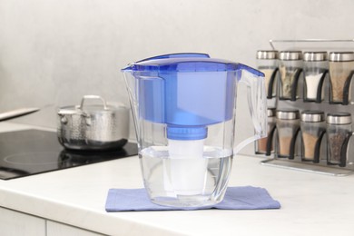 Photo of Water filter jug on white countertop in kitchen