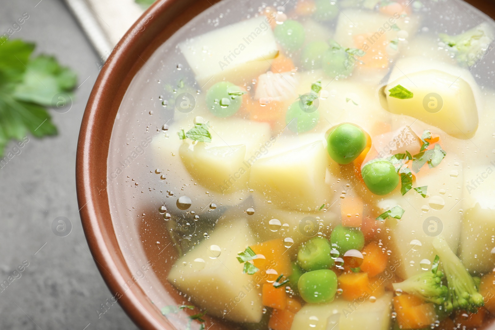 Photo of Bowl of fresh homemade vegetable soup on table, closeup