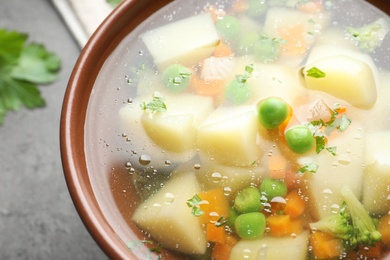 Bowl of fresh homemade vegetable soup on table, closeup