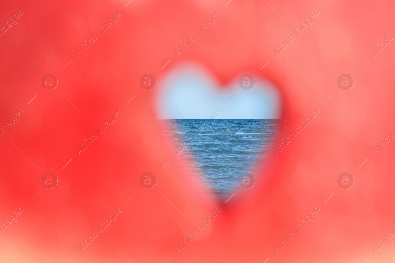 Photo of View on sea through heart shaped hole in watermelon