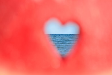 View on sea through heart shaped hole in watermelon