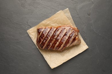 Photo of Delicious grilled beef steak on dark gray table, top view