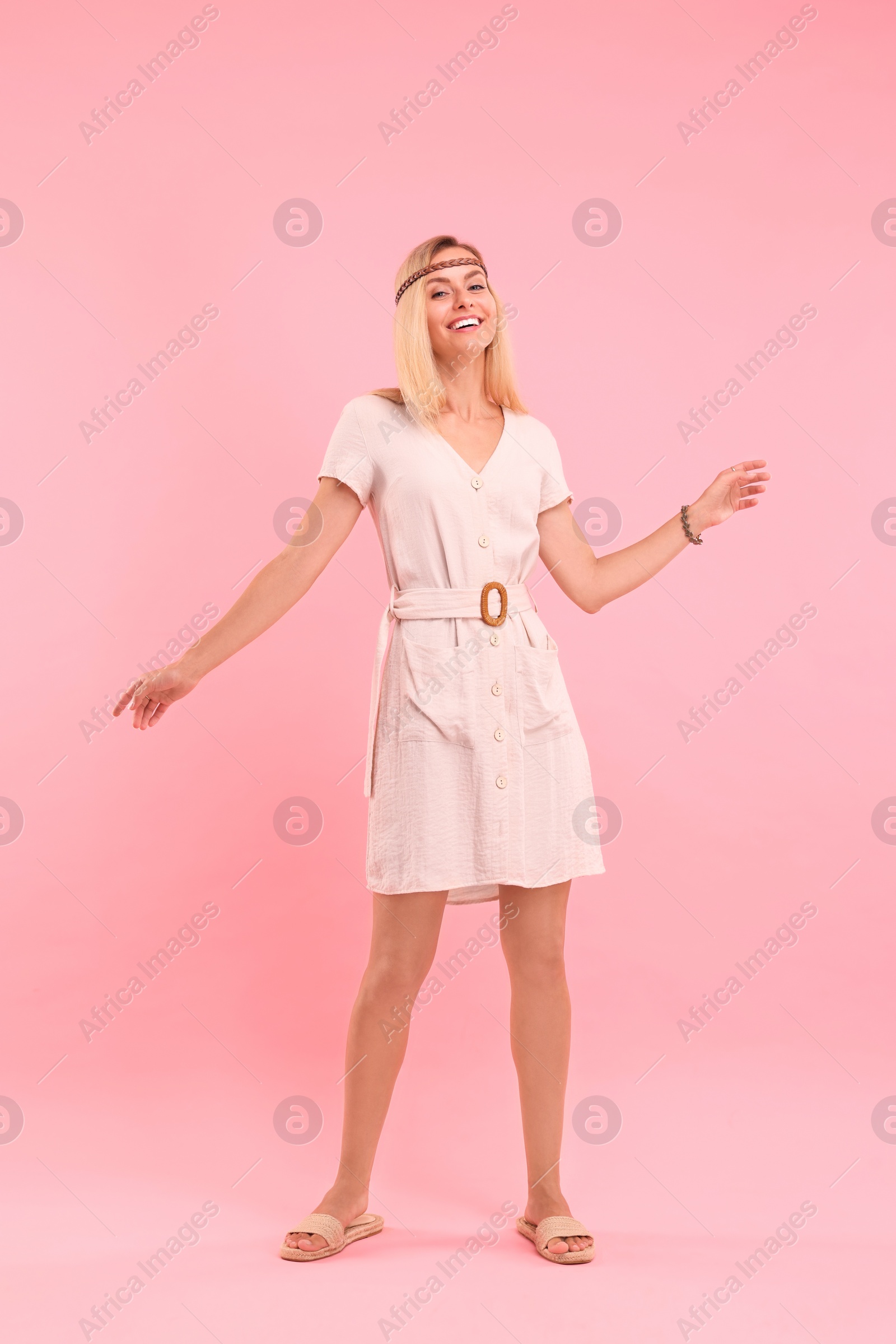 Photo of Happy hippie woman dancing on pink background