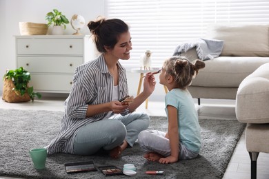 Photo of Young mother and her daughter spending time together at home