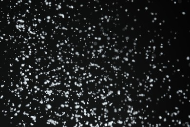 Photo of White snow falling down on black background