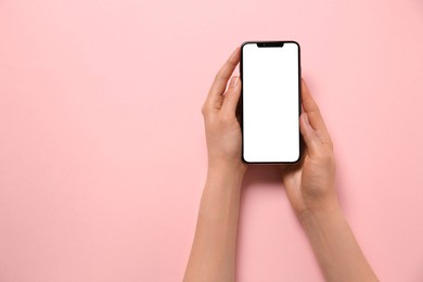 Photo of Woman with smartphone on pink background, top view. Space for text