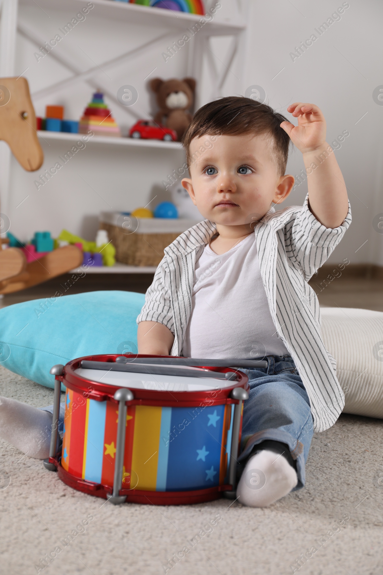 Photo of Cute little boy with toy drum at home