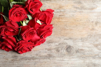 Photo of Beautiful red rose flowers on wooden background