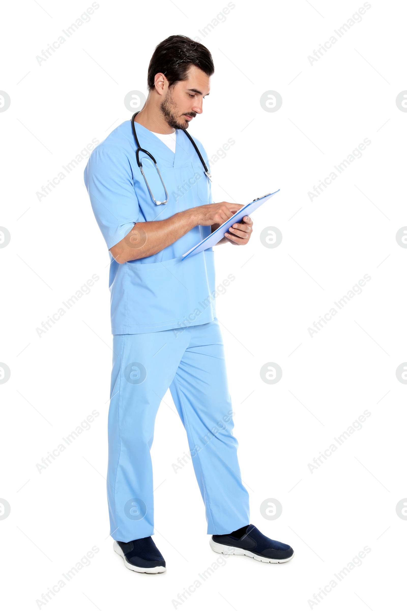 Photo of Young male doctor in uniform with stethoscope and clipboard on white background. Medical service