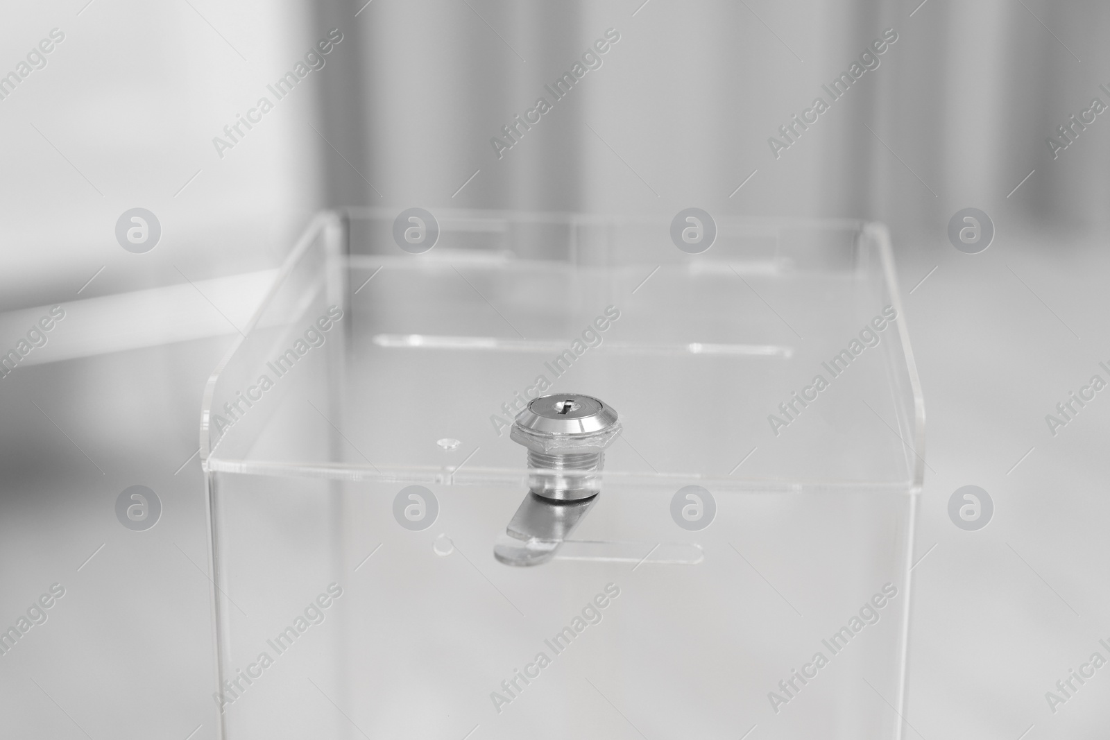 Photo of Transparent ballot box on blurred background, closeup