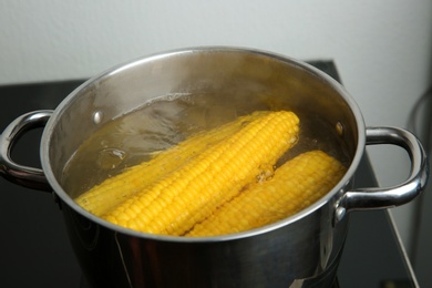 Photo of Boiling fresh corns in pot with hot water on stove