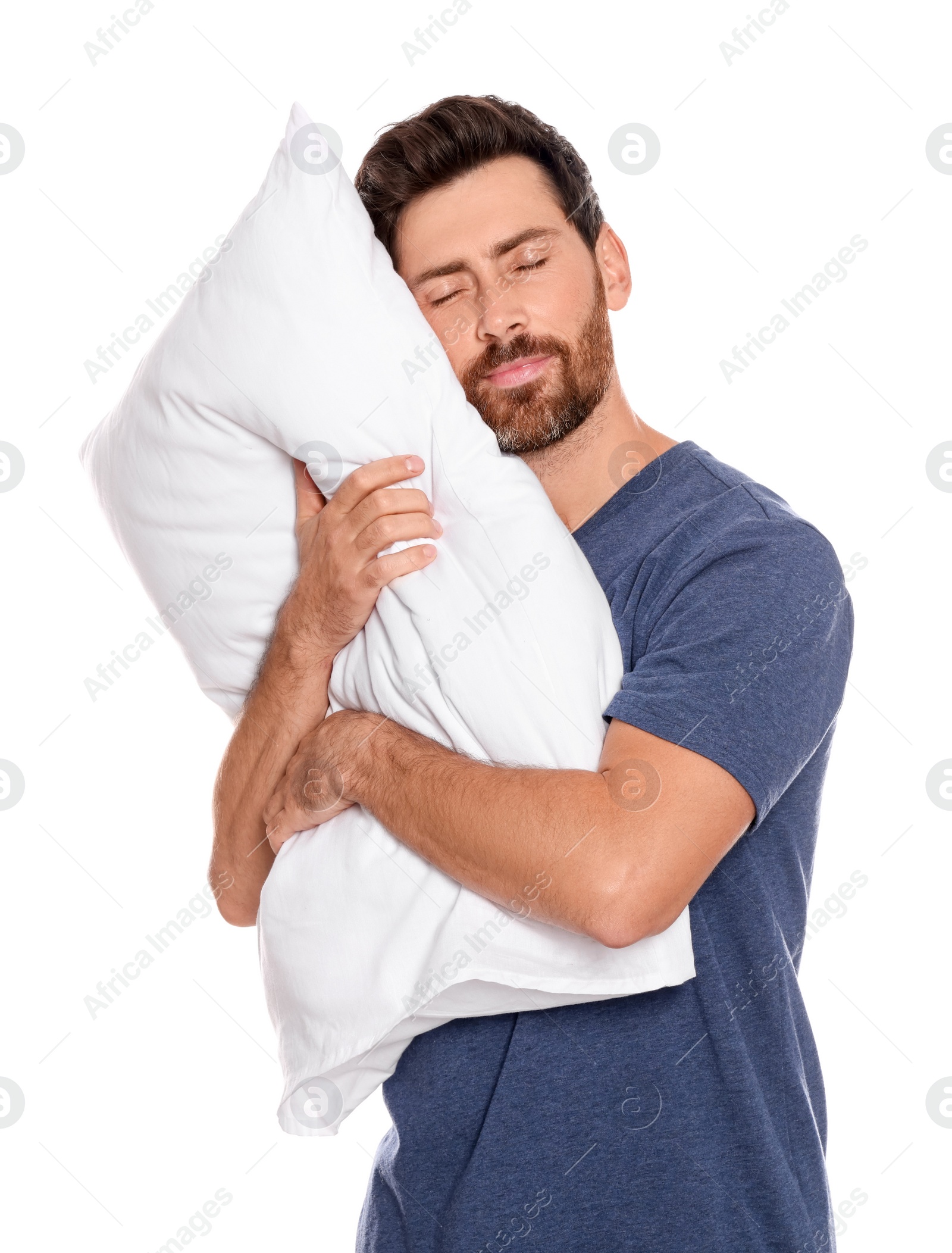 Photo of Sleepy handsome man hugging soft pillow on white background