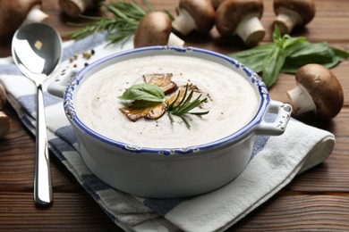 Photo of Delicious homemade mushroom soup served on wooden table, closeup