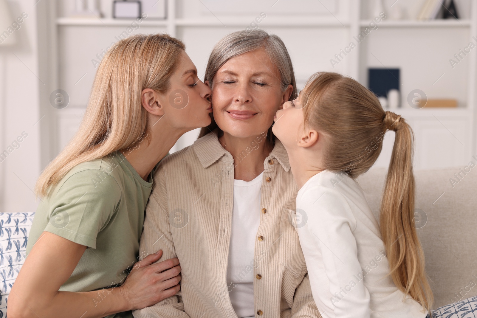 Photo of Three generations. Happy grandmother, her daughter and granddaughter at home