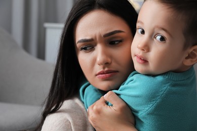 Photo of Depressed single mother with child at home, closeup