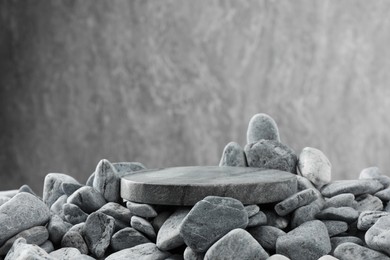 Photo of Presentation for product. Stone and pebbles on grey background. Space for text