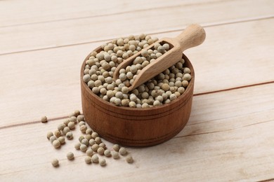 Photo of Aromatic spice. White peppers and scoop in bowl on wooden table