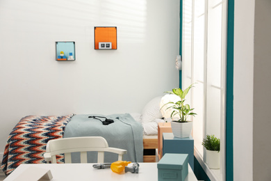 Photo of Modern child room interior with comfortable bed near window