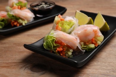 Tasty spring rolls on wooden table, closeup