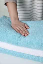 Woman touching soft white towel, closeup view