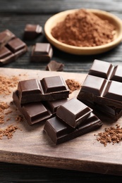 Pieces of black chocolate on wooden board