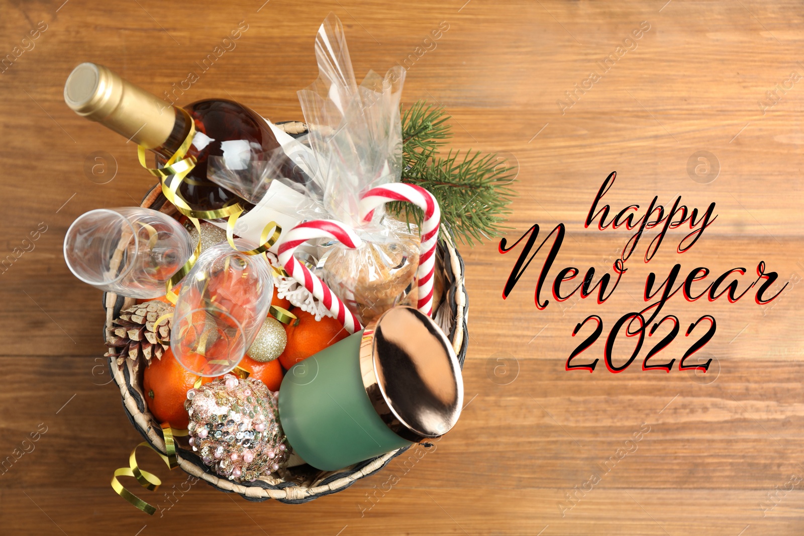 Image of Happy New 2022 Year! Basket with gift set on wooden table, top view