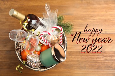 Image of Happy New 2022 Year! Basket with gift set on wooden table, top view
