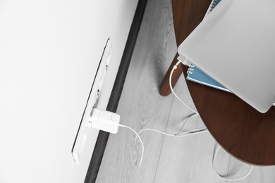 Electric power outlet sockets with charger on white wall, above view