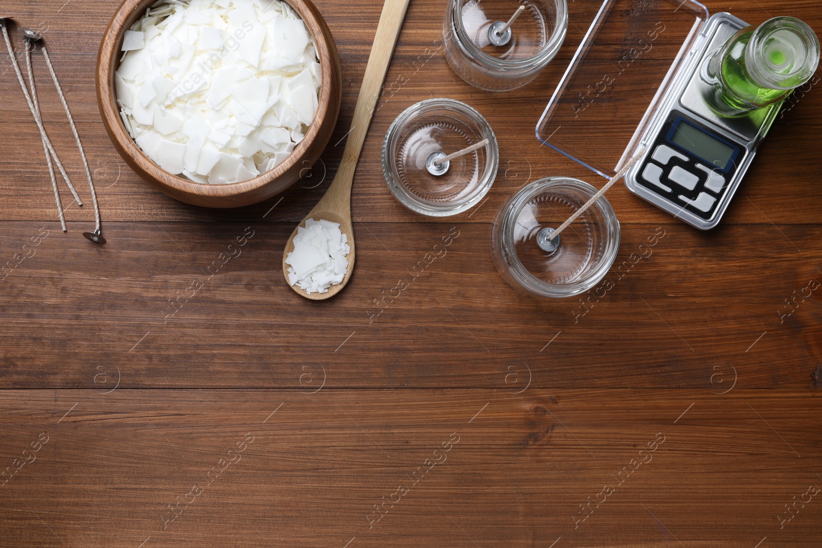 Photo of Flat lay composition with homemade candles ingredients on wooden background, space for text