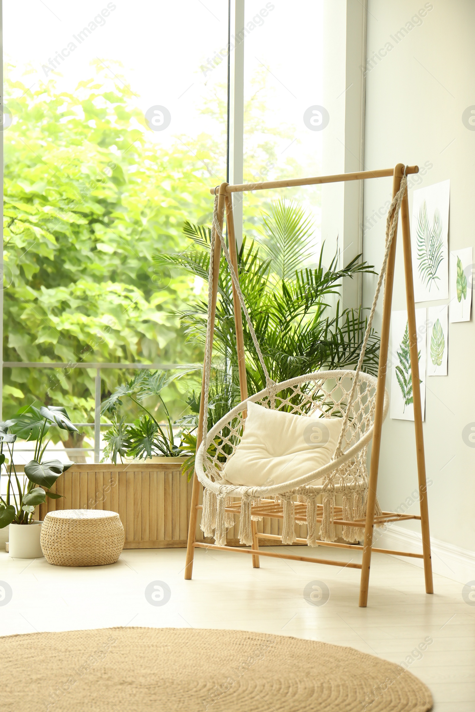 Photo of Comfortable hammock chair in stylish room. Home interior