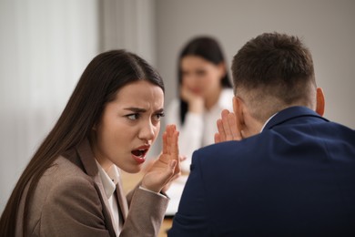 Coworkers bullying their colleague at workplace in office,