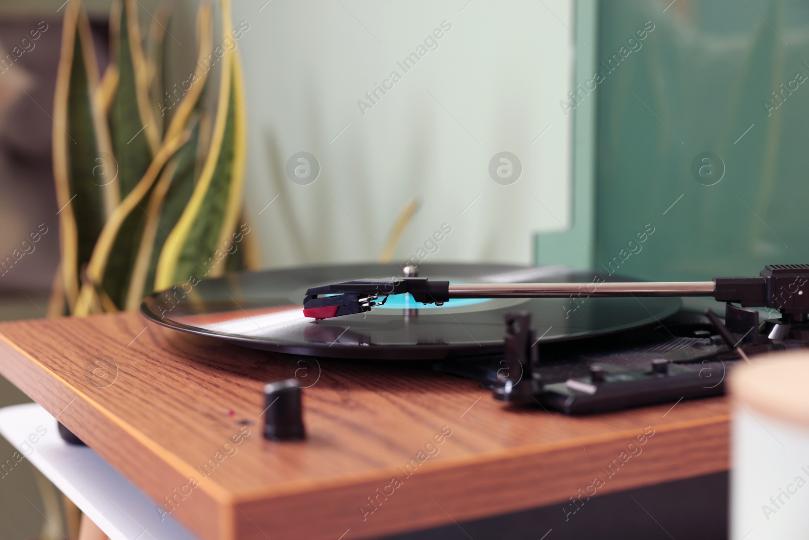 Photo of Stylish turntable with vinyl record indoors, closeup