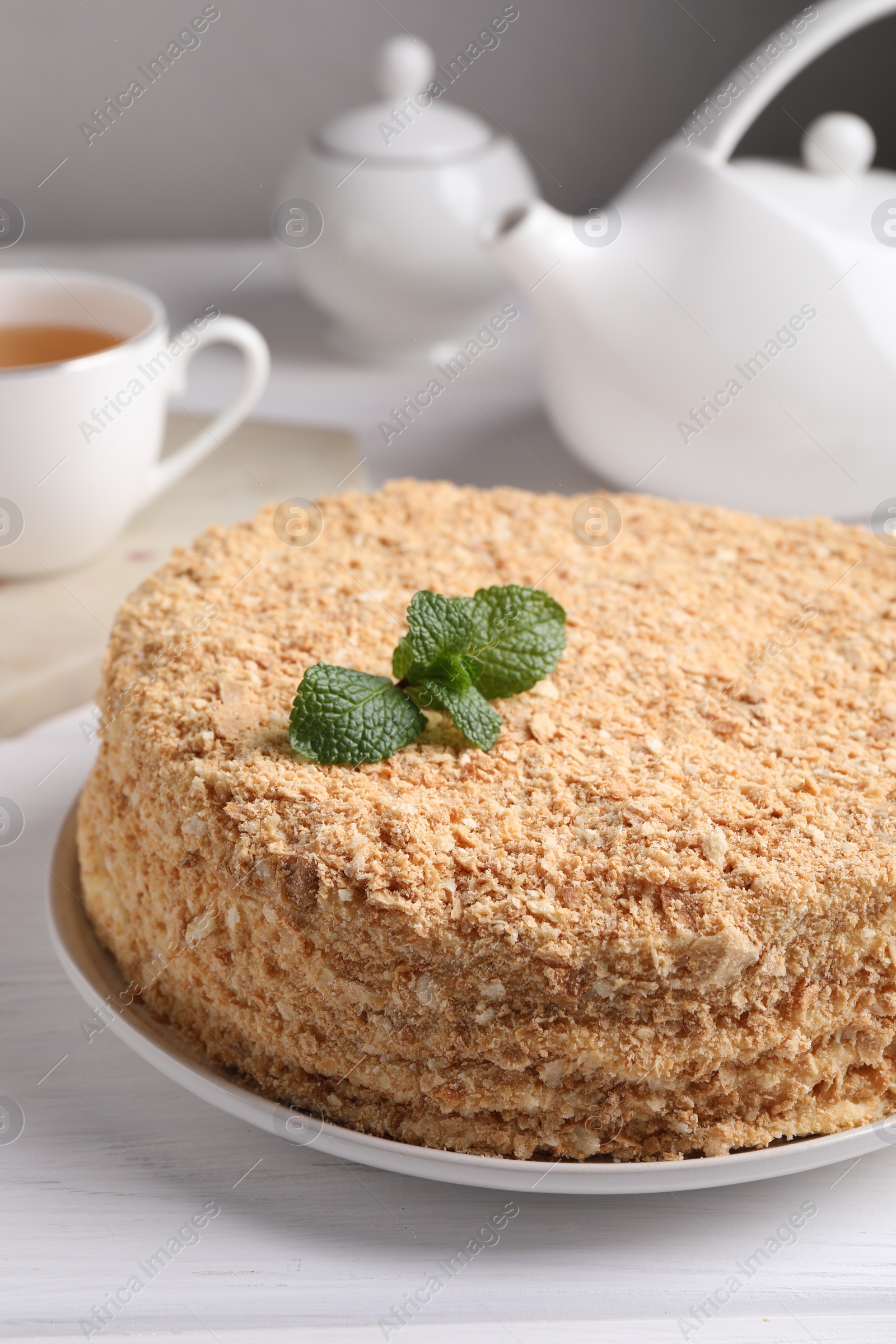 Photo of Delicious Napoleon cake served on white wooden table, closeup