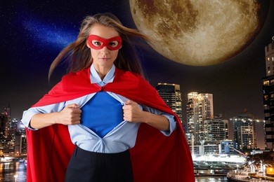 Image of Confident businesswoman wearing superhero costume under suit and beautiful cityscape in night on background