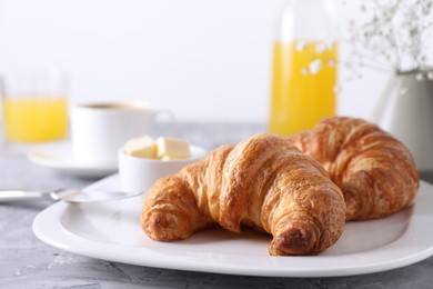 Photo of Tasty breakfast. Fresh croissants and butter on grey table, closeup