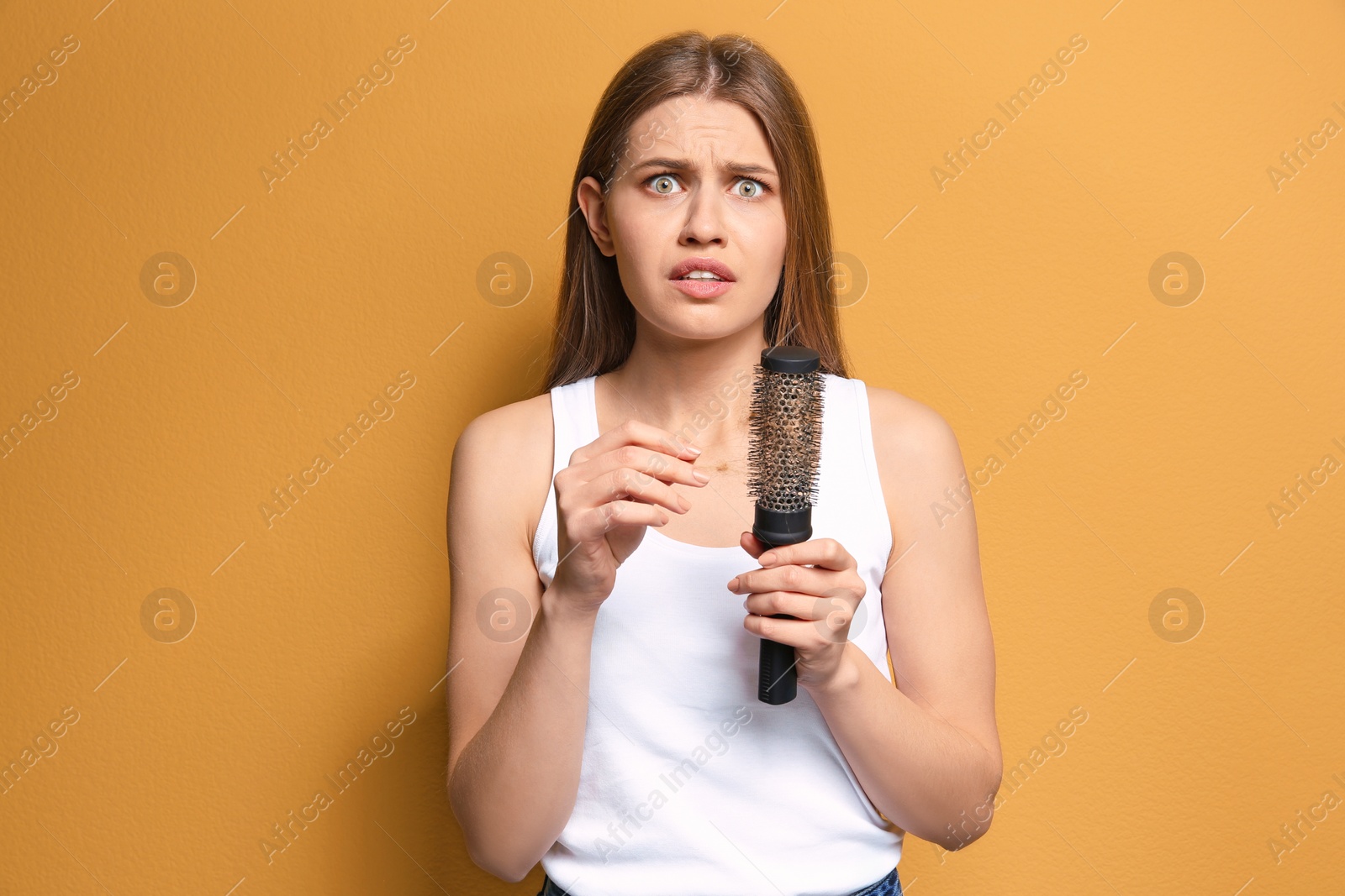 Photo of Young woman with hair loss problem on color background