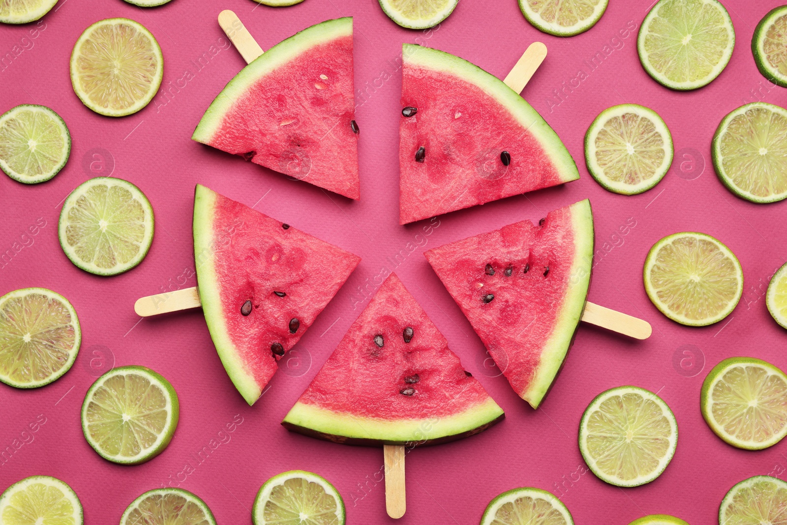 Photo of Tasty sliced watermelon and limes on red background, flat lay