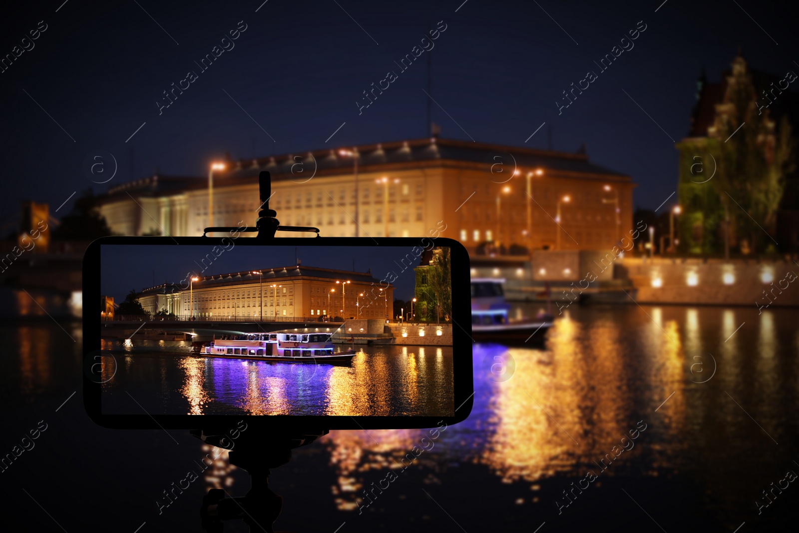 Image of Taking photo of beautiful cityscape at night with smartphone mounted on tripod