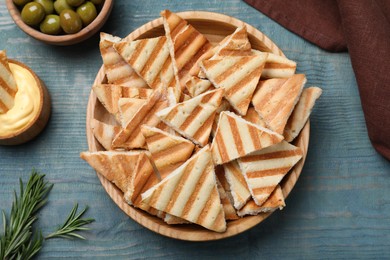 Photo of Delicious pita chips on blue wooden table, flat lay