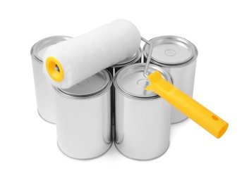 Cans of paints and roller on white background